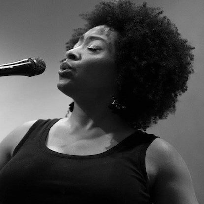 Tonya Abernathy in black and white singing into a microphone