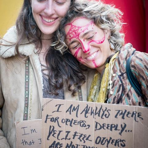 Two women holding Vulnerable Rally signs