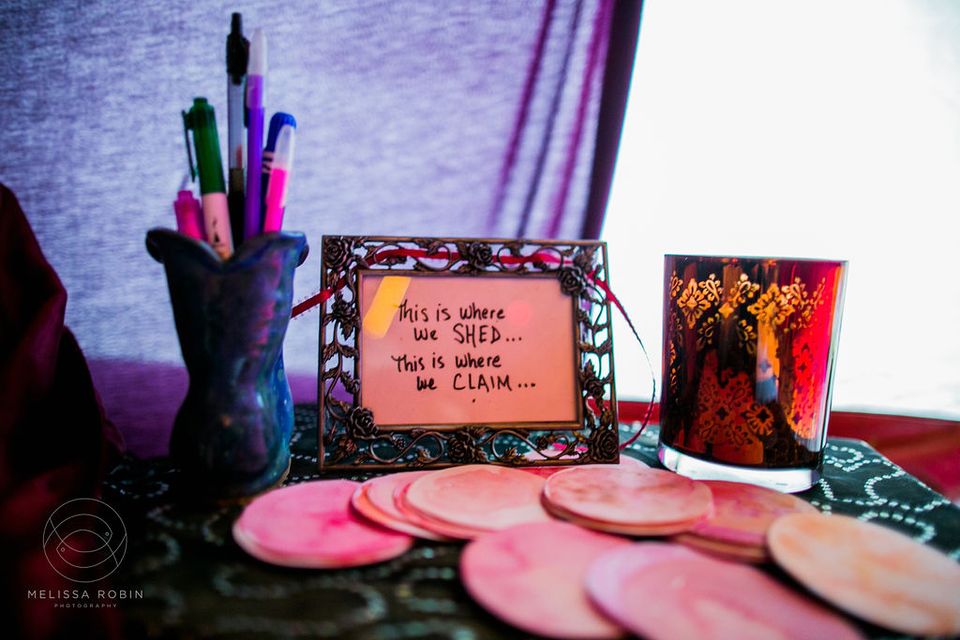 Red Tent table with sign "this is where we shed...this is where we claim"