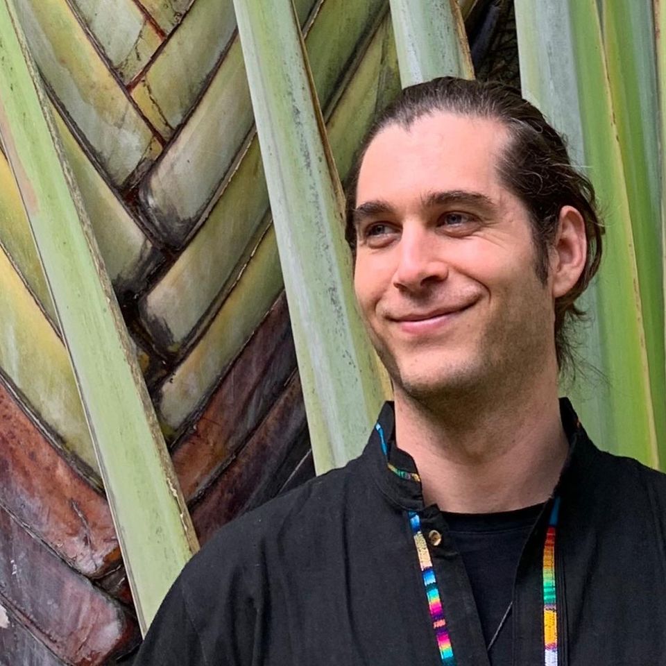 Mark Farry in front of a very large plant smiling Mark Farry in front of a very large plant smiling