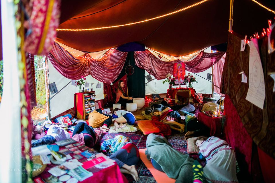 Red Tent Interior, people are lying on the floor, red fabric around.