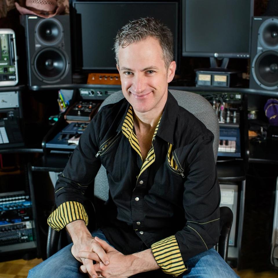 Jake Perrine smiling in front of a lot of audio equipment Jake Perrine smiling in front of a lot of audio equipment