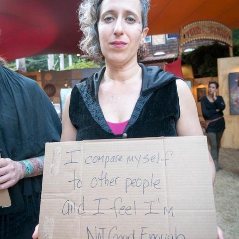 Person holding Vulnerable Rally sign that says, I compare myself to other people and I feel I'm Not Good Enough