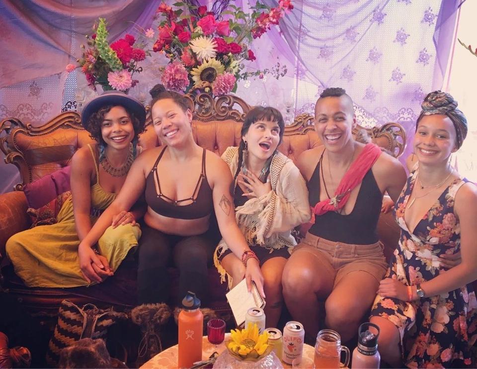 Some of the BIPOC Sanctuary organizers on a yellow velvet couch smiling Some of the BIPOC Sanctuary organizers on a yellow velvet couch smiling
